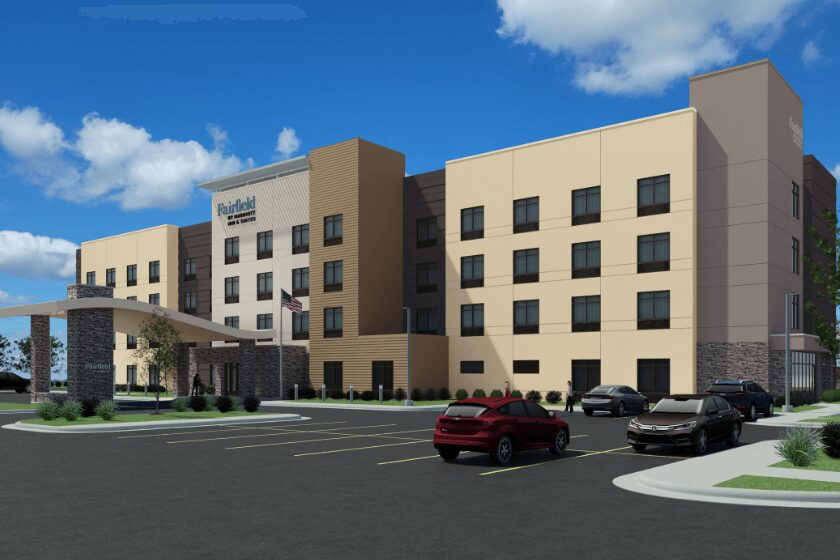 Modern four-story hotel with cars parked