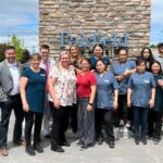 Hotel staff group portrait outside Fairfield sign